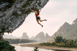 Woman hanging from a cliff.