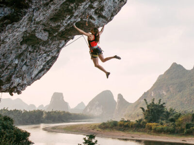 Woman hanging from a cliff.